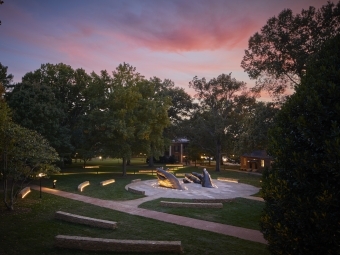 A sculpture in front of a colorful sunset on Davidson's Campus