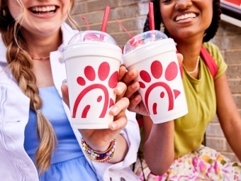 two young women hold up milkshakes from chick-fil-a