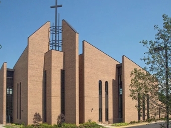 Red brick Catholic church with a crucifix and several brick accent walls