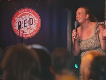 Hannah performs onstage in QUED
