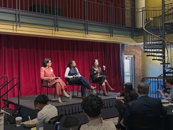 Three female panelists sit onstage in the 900 room on Davidson's campus