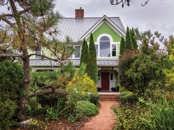 The Center for Conscious Living and Dying a green house in a wooded setting