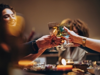 Artistic image of dinner guests toasting glasses of wine