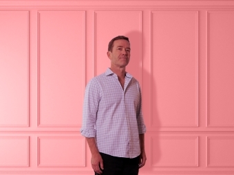 Man standing against pink wainscoting