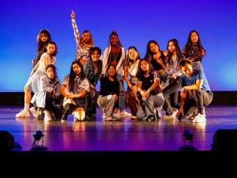 a group of students pose together after a dance performance on stage