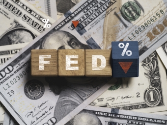 Stack of US Dollars with letters FED on top and percentage sign