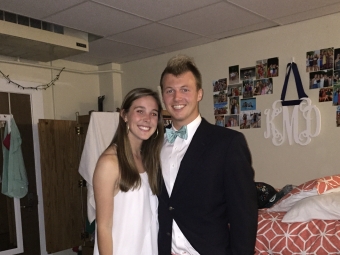 A young couple in the early 2000s, wearing a white dress and a suit and bow tie with pink pants