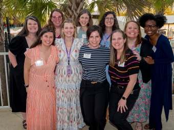 A group of 10 women of varying ages take a group photo outside