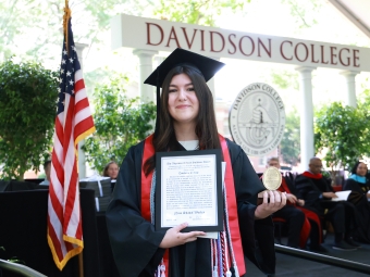 Nina Worley holds an award at commencement