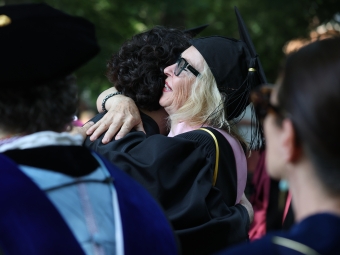 A blonde professor hugs a student