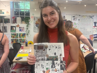 A smiling student holds up a handmade collage featuring black-and-white illustrations and text snippets in a bright, decorated art studio.