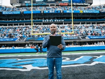 Daniel Heath reading to the crowd as the inaugural chaplain for Charlotte Football Club (Charlotte FC),