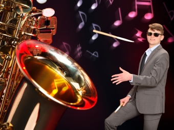 A giant saxophone and student with a drumstick