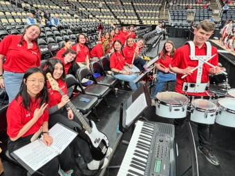 Students in red shirts with instruments