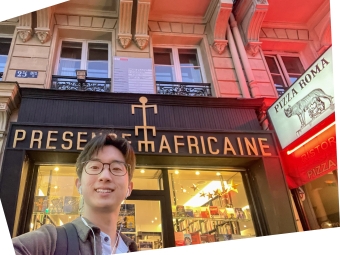 A young man taking a selfie outside the "Présence Africaine" storefront