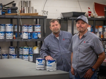 Physical Plant Staff with paint cans in the shop
