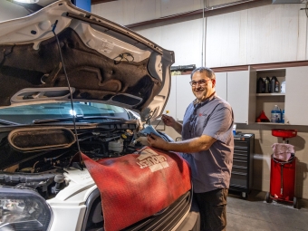 Physical Plant Staff with car in the mechanical shop