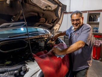 Physical Plant mechanic working on a truck engine