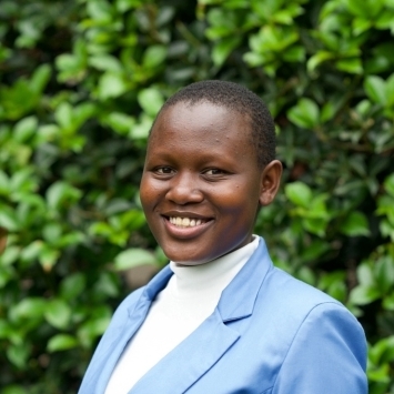 a young African woman wearing a white top and blue blazer