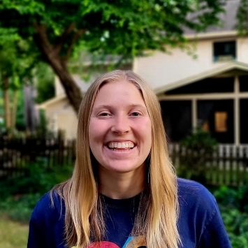 a young white woman with blonde hair smiling outside