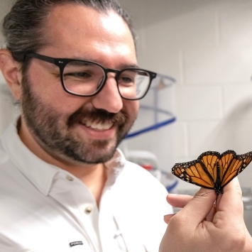 Assistant Professor of Biology Scott Villa holding a butterfly