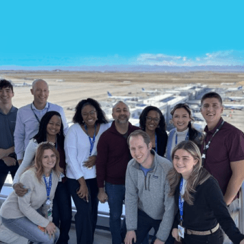 Group of people stand on a platform in an airport
