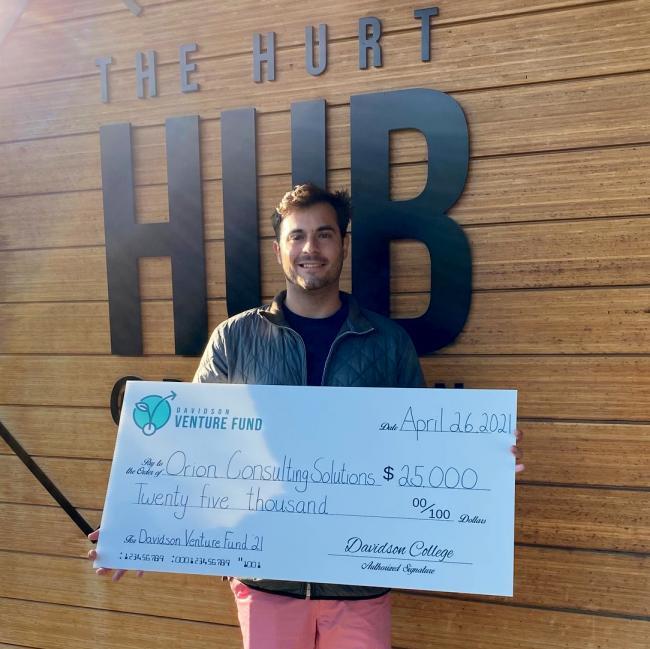 Owen Bezick '21 Claims Prize Check in Front of Hurt Hub