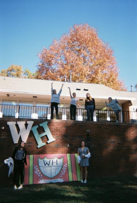 a group of young women standing on a brick porch with the letters "W" and "H"