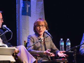 Prof. Susan Roberts sit in on an NPR panel, and speaks into a microphone while seated on stage