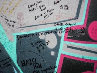 a teal and pink wall signed by people including "Davidson in Northern Ireland"